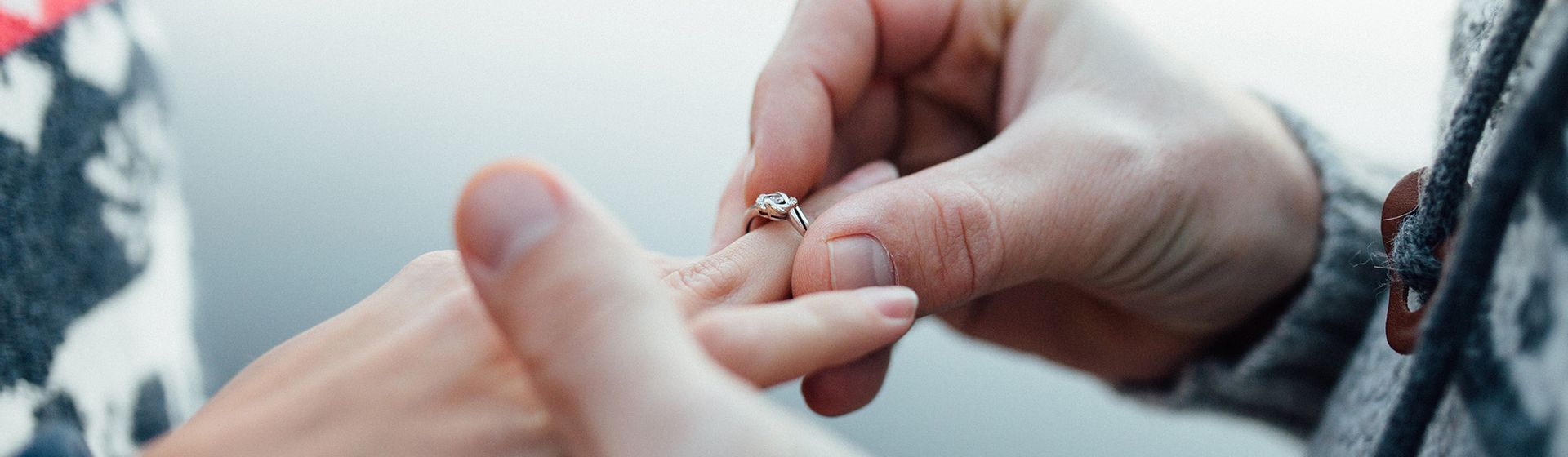Een man die een ring om de ringvinger schuift bij zijn verloofde | Het Notarieel